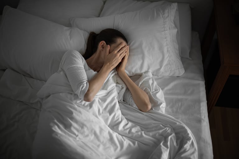 Persona con insomnio y dolor de hombro acostada en la cama durante la noche sin poder descansar
